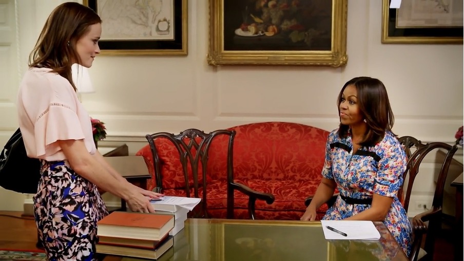 Rory at the White House with Michelle Obama. The two are talking and Rory is putting stacks of books on the First Lady's desk.