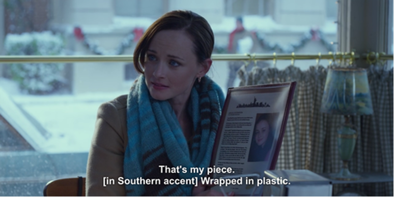 An older Rory reads her New Yorker essay from a menu in a diner. The subtitles read: "That's my piece. [in Southern accent] Wrapped in plastic."
