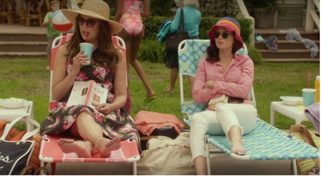 Lorelai and Rory lounging on sunbeds. Rory is holding a copy of Anna Karenina, Lorelai a copy of Cheryl Strayed's Wild.