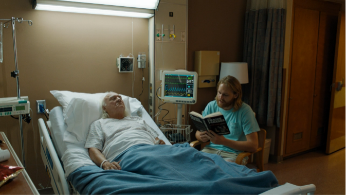 Dud reading to Larry Loomis in the hospital. 