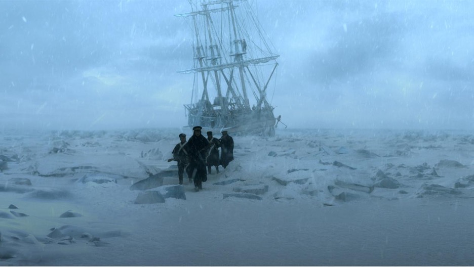 a wintry-blue television still of a slightly-listing nineteenth-century masted sailing ship, frozen in the ice, in front of which a group of four uniformed British sailors march over pressure ridges