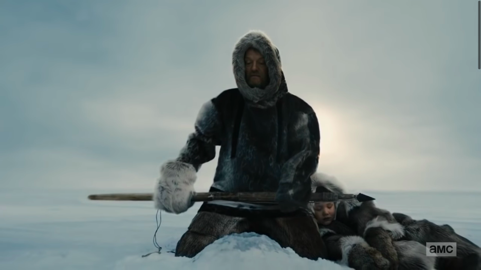 a television still of Jared Harris as Francis Crozier, wearing a hooded sealskin anorak and heavy gloves, holding a harpoon, sitting on his heels over a seal hole in the ice, while an Inuk child of about five or six naps at his feet in furs.